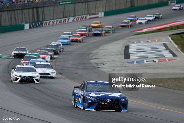 Martin Truex Jr., driver of the Auto-Owners Insurance Toyota, leads a pack of cars during the Monster Energy NASCAR Cup Series Quaker State 400...