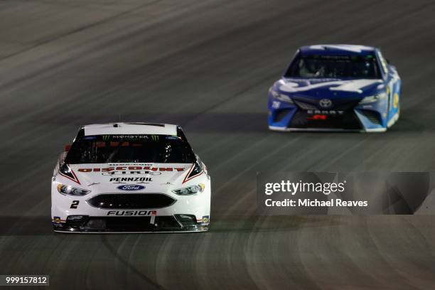 Brad Keselowski, driver of the Discount Tire Ford, leads Martin Truex Jr., driver of the Auto-Owners Insurance Toyota, during the Monster Energy...