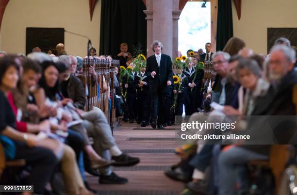 New members of the Thomanerchor of the 4th and 5th grade lay down a sunflower at the grave of Johann Sebastian Bach together with Thomas cantor...