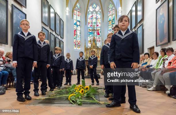 New members of the Thomanerchor of the 4th and 5th grade lay down a sunflower at the grave of Johann Sebastian Bach before the beginning of a motet...