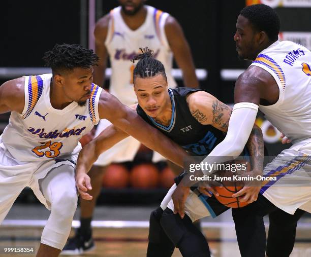 Tyrone Bash and Jordan Adams of the Sons of Westwood guard Johnathan Ivy of the D3 during the Western Regional of The Basketball Tournament game at...