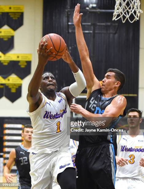 Jordan Adams of the Sons of Westwood gets past Ben Strong of the D3 for a basket during the Western Regional of The Basketball Tournament game at...