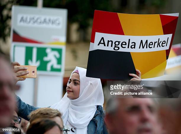 Muslim supporter of the German Chancellor follows the campaign appearance of the Christian Democratic Union of Germany for the federal parliamentary...