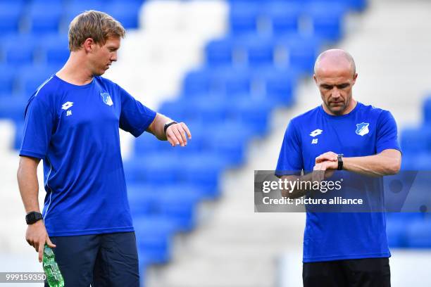 Hoffenheim's coach Julian Nagelsmann and co-coach Alfred Schreuder look at their watches during the training session in preparation of the Champions...