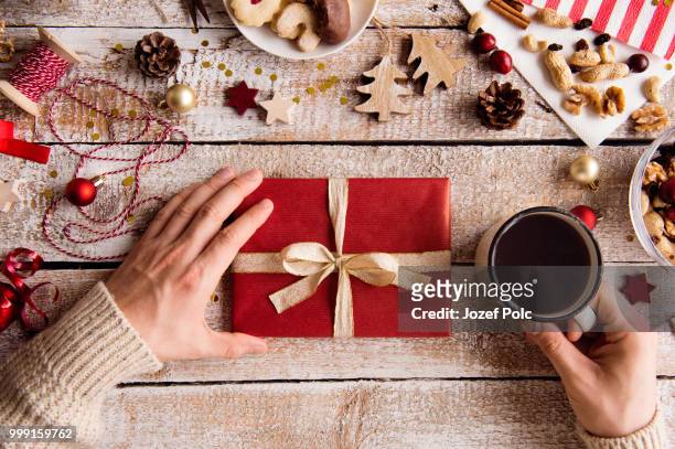 man holding christmas present and cup of coffee. studio shot. - jozef polc stock pictures, royalty-free photos & images