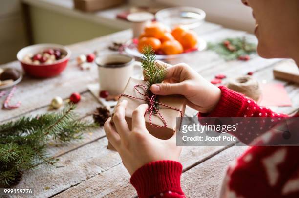 unrecognizable woman wrapping and decorating christmas present - jozef polc stock pictures, royalty-free photos & images