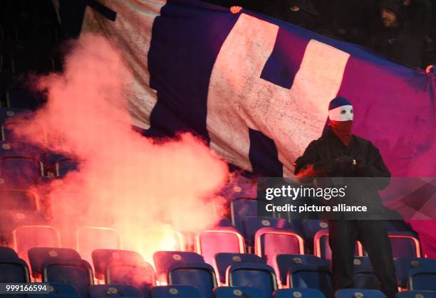 Dpatop - Rostock hooligans set stadium seats on fire as welk as a Berlin banner during the DFB Cup match pitting Hansa Rostock vs Hertha BSC at the...