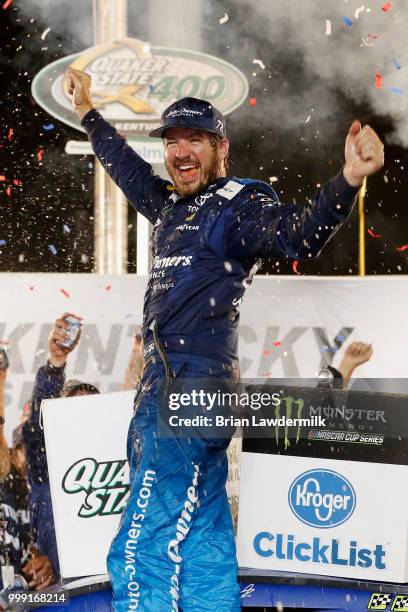 Martin Truex Jr., driver of the Auto-Owners Insurance Toyota, celebrates in Victory Lane after winning the Monster Energy NASCAR Cup Series Quaker...