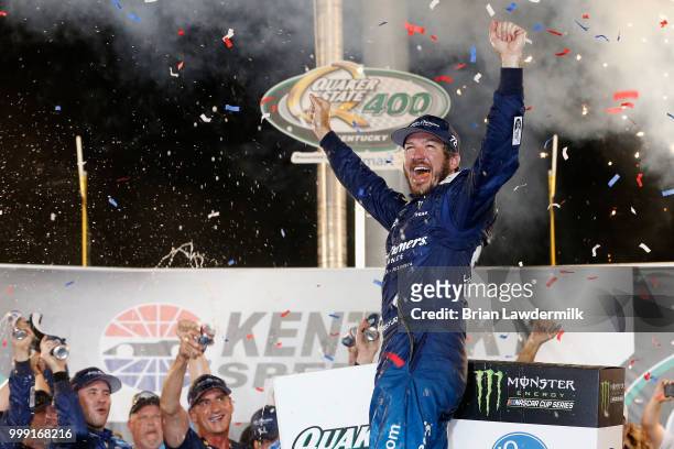 Martin Truex Jr., driver of the Auto-Owners Insurance Toyota, celebrates in Victory Lane after winning the Monster Energy NASCAR Cup Series Quaker...