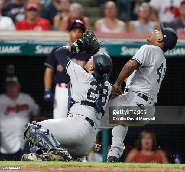 Miguel Andujar and Austin Romine of the New York Yankees get tangled up while pursuing a pop up by Brandon Guyer of the Cleveland Indians in the...