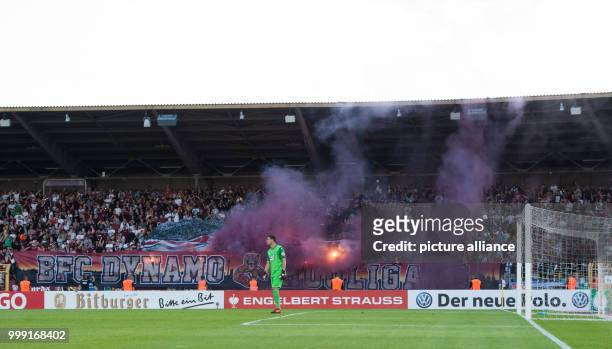 Dynamo supporters lighting fireworks and holding a banner with the text "BFC Dynamo Hooligans" ahead of the start of the second half-time of the...