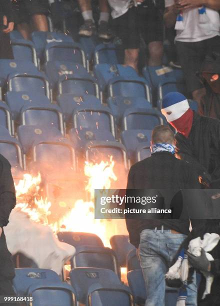 Spectators setting stadium seats on fire during the DFB Cup match pitting Hansa Rostock vs Hertha BSC at the Ostsee Stadium in Rostock, Germany, 14...