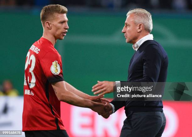 Rostock head coach Pavel Dotchev congratulates Berlin's Mitchell Weiser during the DFB Cup match pitting Hansa Rostock vs Hertha BSC at the Ostsee...