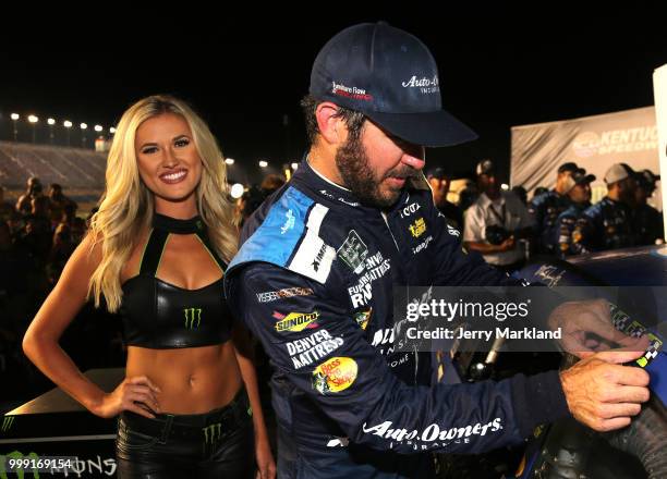 Martin Truex Jr., driver of the Auto-Owners Insurance Toyota, poses with the winner's decal in Victory Lane after winnin the Monster Energy NASCAR...