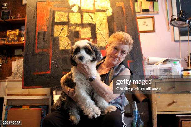 Artist Carol Massa sitting with her dog Bleu in front of her painting "The Last Curtain" in her house in New York, US, 14 August 2017. Massa is on...