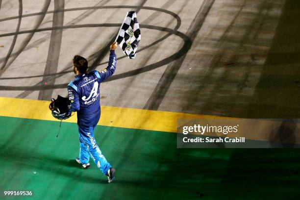 Martin Truex Jr., driver of the Auto-Owners Insurance Toyota, celebrates winning the Monster Energy NASCAR Cup Series Quaker State 400 presented by...