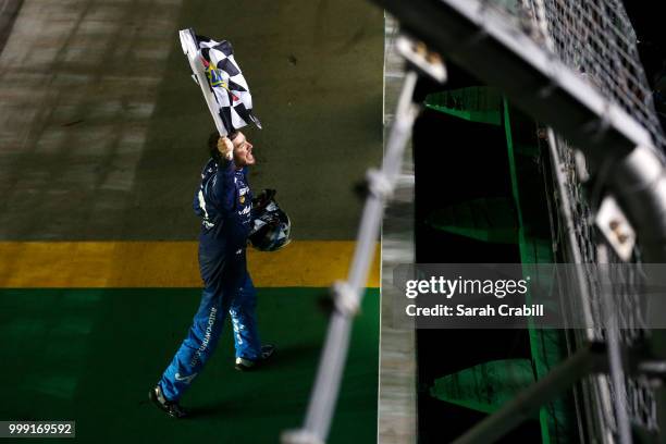 Martin Truex Jr., driver of the Auto-Owners Insurance Toyota, celebrates winning the Monster Energy NASCAR Cup Series Quaker State 400 presented by...