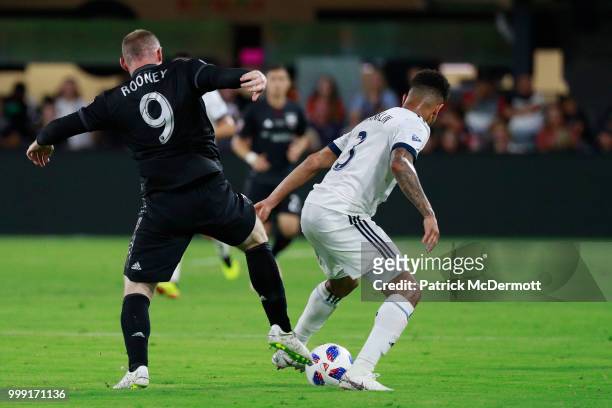 Wayne Rooney of D.C. United and Sean Franklin of Vancouver Whitecaps battle for the ball in the second half at Audi Field on July 14, 2018 in...