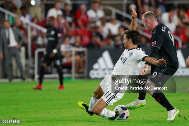 Wayne Rooney of D.C. United and Nicolas Mezquida of Vancouver Whitecaps battle for the ball in the second half at Audi Field on July 14, 2018 in...