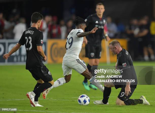 Wayne Rooney of DC United fights for the ball with Yordy Reyna during the DC United vs the Vancouver Whitecaps FC match in Washington DC on July 14,...