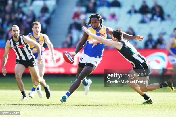 Nic Naitanui of the Eagles kicks the ball past Scott Pendlebury of the Magpies during the round 17 AFL match between the Collingwood Magpies and the...