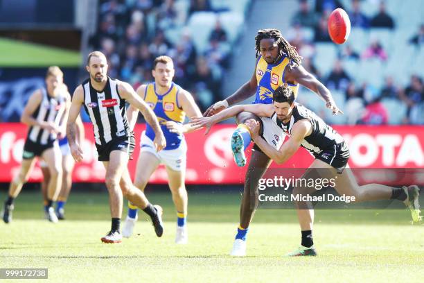 Nic Naitanui of the Eagles kicks the ball past Scott Pendlebury of the Magpies during the round 17 AFL match between the Collingwood Magpies and the...