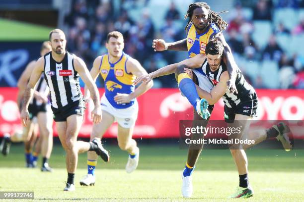 Nic Naitanui of the Eagles kicks the ball past Scott Pendlebury of the Magpies during the round 17 AFL match between the Collingwood Magpies and the...