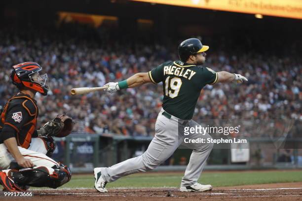Josh Phegley of the Oakland Athletics swings for a sacrifice fly during the second inning against the San Francisco Giants at AT&T Park on July 14,...