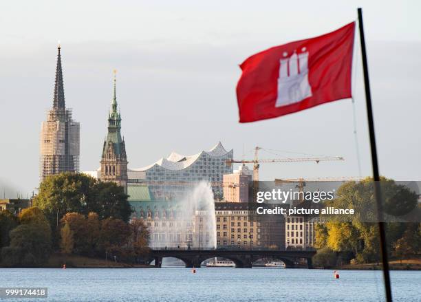 File picture dated 29 October 2016 shows a Hamburg flag by the Outer Alster lake with the town hall, the Elbe Philharmonic Hall and the Alster...