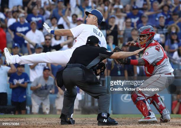 Homeplate umpire David Rackley calls Chase Utley of the Los Angeles Dodgers safe at the plate as catcher Martin Maldonado of the Los Angeles Angels...