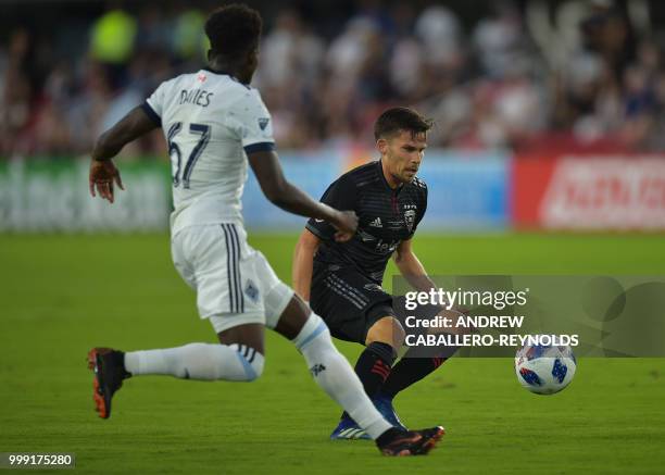 Zoltan Stieber of DC United vies for the ball with Alphonso Davies during the DC United vs the Vancouver Whitecaps FC match in Washington DC on July...
