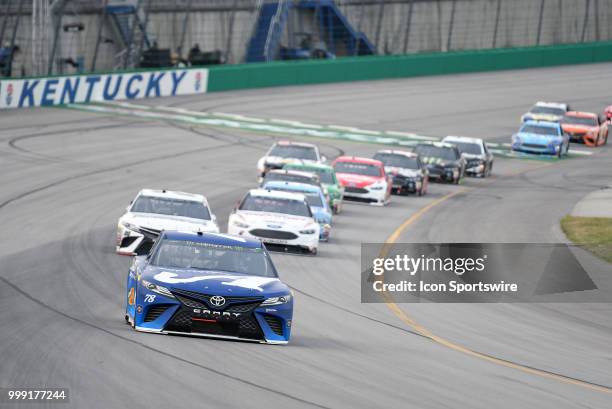 Martin Truex Jr Barney Visser Furniture Row Racing Toyota Camry leads the field down the front stretch during the early laps of the Monster Energy...