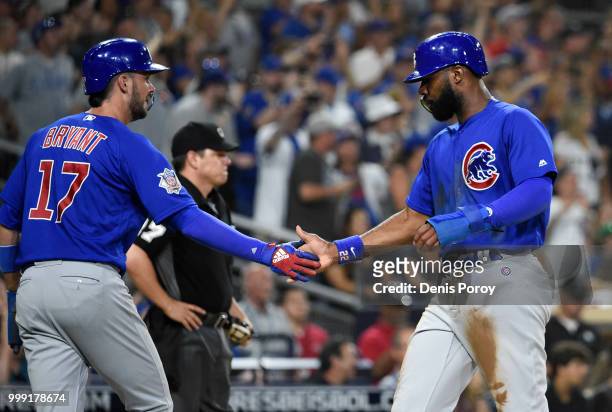 Jason Heyward of the Chicago Cubs is congratulated by Kris Bryant after scoring during the fifth inning of a baseball game against the San Diego...