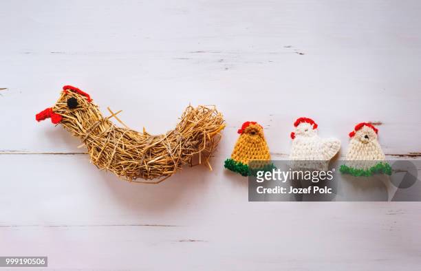 three crocheted easter chickens and straw hen,white wooden backg - jozef polc stock pictures, royalty-free photos & images