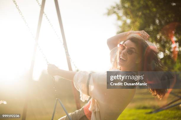 schöne junge frau auf einer schaukel auf sommer tag im freien - woman on swing stock-fotos und bilder