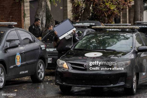 Member of the Venezuelan police carries a computer as police search the apartment of ousted attorney general Luisa Ortega in Caracas, Venezuela, 16...