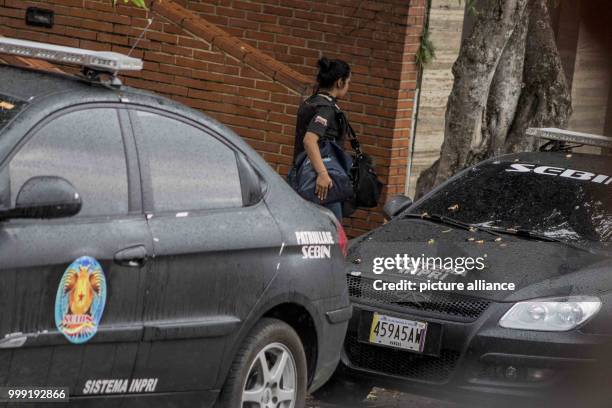 Member of the Venezuelan police carries two bags as police search the apartment of ousted attorney general Luisa Ortega in Caracas, Venezuela, 16...