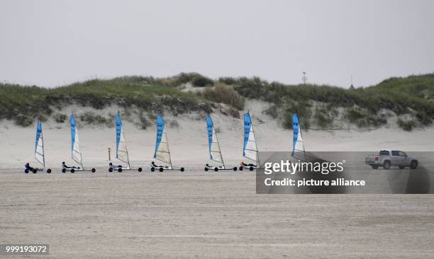 Sand yachts are being pulled by a car onto the training ground at the beach of the North Sea in St. Peter-Ording, Germany, 17 August 2017. Photo:...