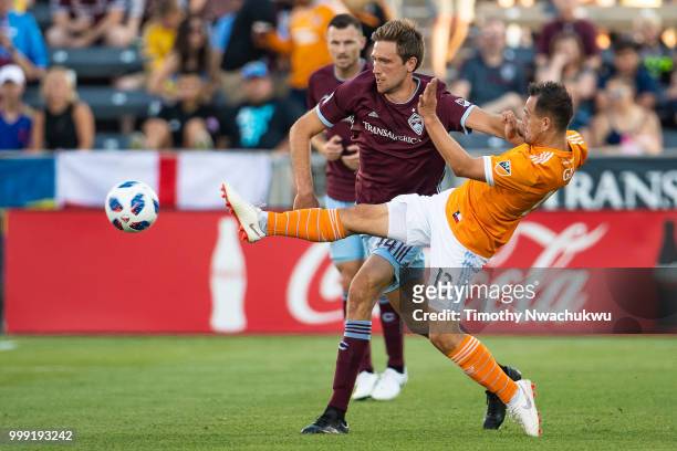 Luis Gil of Houston Dynamo clears the ball past Axel Sjoberg of Colorado Rapids at Dick's Sporting Goods Park on July 14, 2018 in Commerce City,...