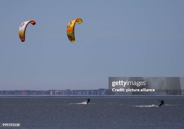 June 2018, Germany, Norddeich: A view of two kitesurfers on the North Sea. Photo: Mohssen Assanimoghaddam/dpa