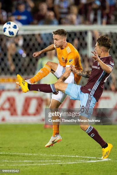 Adam Lundqvist of Houston Dynamo and Sam Nicholson of Colorado Rapids reach for a volley at Dick's Sporting Goods Park on July 14, 2018 in Commerce...