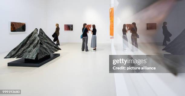 Several women seen next to a bronze pyramid by artist Emil Cimiotti from 1991 during a press preview of the 'Emil Cimiotti' exhibition at the...