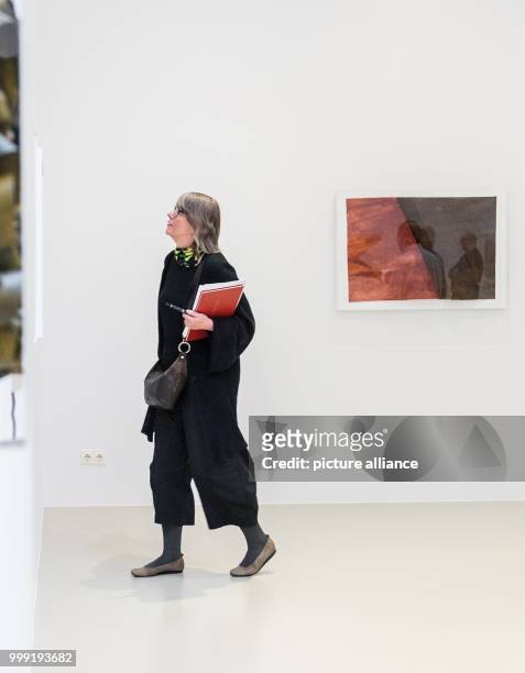 Woman looks at paper reliefs by artist Emil Cimiotti during a press preview of the 'Emil Cimiotti' exhibition at the Sprengel Museum in Hanover,...