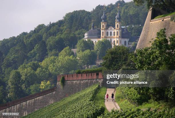 Jogger are running in front of the pilgrimage church "Kaeppele" near the fortress Marienberg in Wuerzburg, Germany, 17 August 2017. Photo: Karl-Josef...