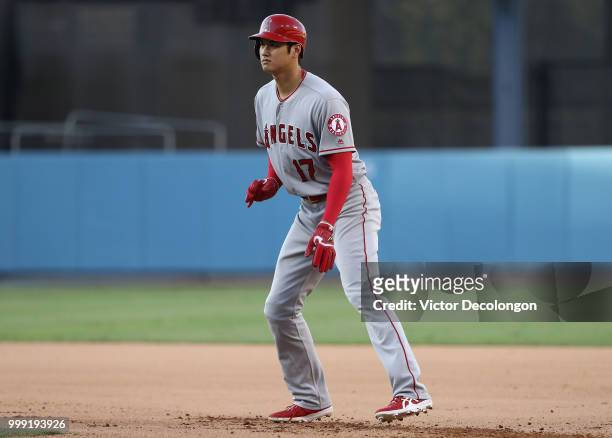 Shohei Ohtani of the Los Angeles Angels of Anaheim leads off at first base in the eighth inning during the MLB game against the Los Angeles Dodgers...