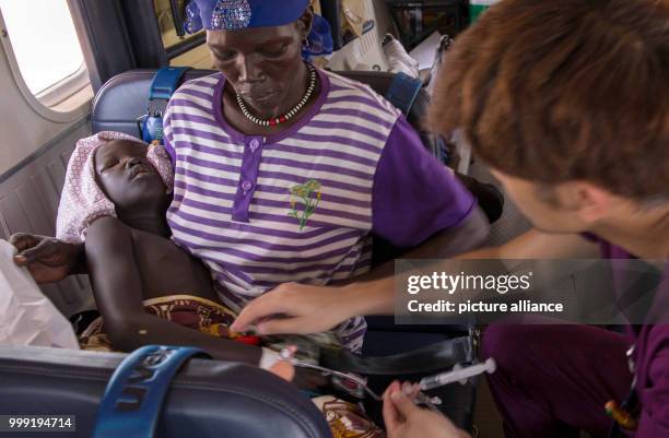 Nurse Yuki Asakura tends to 9-year-old Remaik, who has lost consciousness due to her bullet wound, on the Twin Otter plane evacuating her from Bor to...