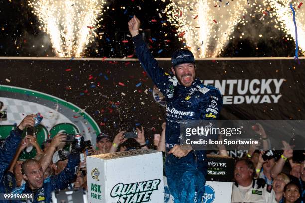 Martin Truex Jr., driver of the Auto-Owners Insurance Toyota, celebrates after winning the Monster Energy NASCAR Cup Series Quaker State 400...