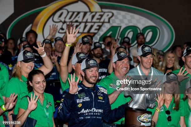 Martin Truex Jr., driver of the Auto-Owners Insurance Toyota, holds up four fingers to signify his four wins at Kentucky Speedway in the Monster...