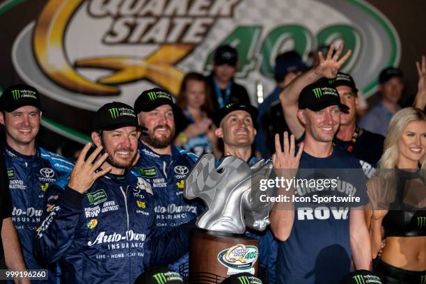 Martin Truex Jr., driver of the Auto-Owners Insurance Toyota, holds up four fingers to signify his four wins at Kentucky Speedway in the Monster...