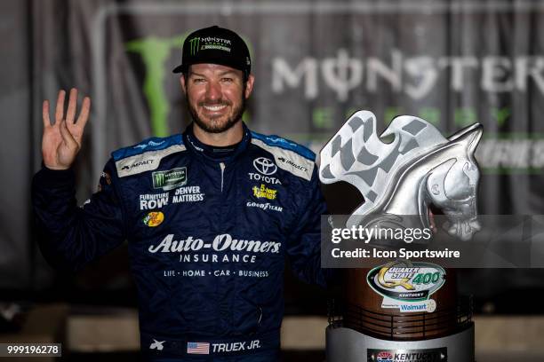 Martin Truex Jr., driver of the Auto-Owners Insurance Toyota, holds up four fingers to signify his four wins at Kentucky Speedway in the Monster...
